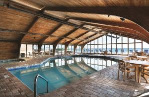 una piscina con mesas y sillas en un edificio en Sands Ocean Club en Myrtle Beach