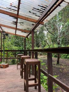 a wooden deck with stools and a wooden pergola at Casa del Bosque in Mar del Plata