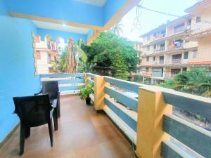 a balcony with two chairs and a blue wall at Calangute in Guest House in Calangute