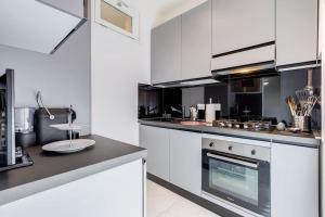 Una cocina con gabinetes blancos y una estufa. en Vatican Escape, en Roma