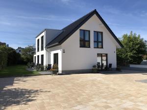 una casa bianca con tetto nero e patio di Gästehaus Witteborg a Paderborn