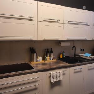 a kitchen with white cabinets and a sink at SAM - your cozy stay near Hamburg-Airport in Hamburg