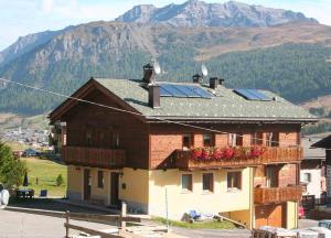 a house with solar panels on top of it with a mountain at Appartamento1 deluxe - Alpen Suite in Livigno
