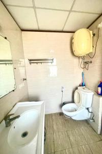 a bathroom with a toilet and a sink at ZenRoofs- Brij Bhumi Haven in Vrindāvan