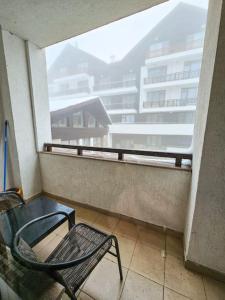 a chair sitting on a balcony looking out a window at Mountain Dream A8 apartment in Borovets