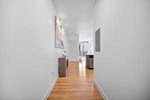 a hallway with white walls and wooden floors at NEW! Luxury Champagne Towers Kingbed FreeParking in Atlanta