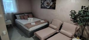 a small bedroom with a bed and a chair at Mini wellness studio-near the airport in Smlednik
