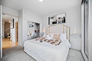 a bedroom with a large white bed with a wooden headboard at NEW! Luxury Champagne Towers Kingbed FreeParking in Atlanta