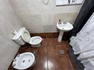 a bathroom with a toilet and a sink at Casa del Bosque in Mar del Plata +6 photos