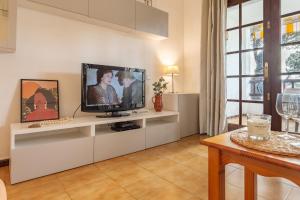 a living room with a tv on a white shelf at Apartamento Gisela in L'Escala