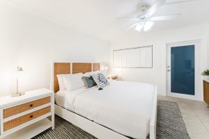 a white bedroom with a bed and a ceiling fan at Elegant Escape! in Boca Raton