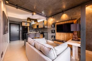 a living room with a couch and a tv at BGV - Le Bougainville By Anora Spaces in Barueri