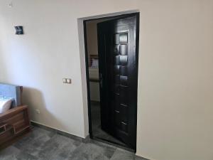 a black door in a room with a mirror at Maison d ampasikely in Nosy Be