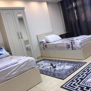 a small room with two beds and a mirror at فندق رويال هوم in Mansoura +2 photos