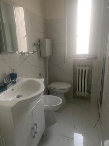 a white bathroom with a sink and a toilet at Casa ELLI in Rimini +6 photos