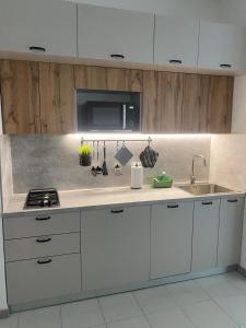 a kitchen with white cabinets and a sink at Casa ELLI in Rimini