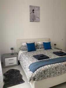 a bedroom with a large bed with blue pillows at Casa ELLI in Rimini