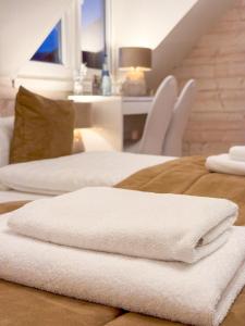 two white towels sitting on top of a bed at Landhotel Engel & Kreuz in Gaggenau