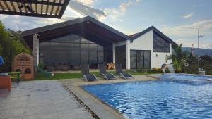 a house with a swimming pool in front of a house at Casa en el Cielo in Cali