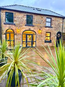 a brick house with palm trees in front of it at The Coach House central location fantastic Views in Matlock