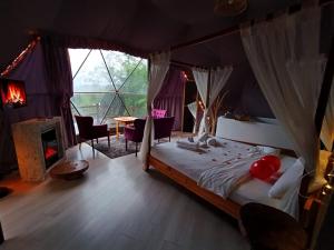 a bedroom with a bed in a tent with a fireplace at ME-GA Glamping in Sapanca