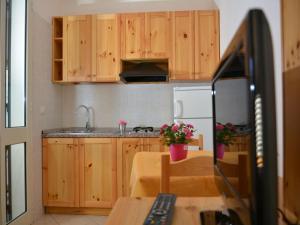 una pequeña cocina con armarios de madera y fregadero en Masseria Lama, en Torre dell'Orso