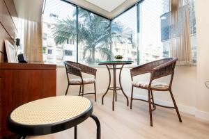 Habitación con 3 sillas, mesa y ventana en Conforto em Apto no Jurerê Open Shopping P1529, en Florianópolis