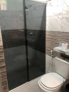 un bagno con wc e doccia in vetro di Pousada Samreny a Maracanã
