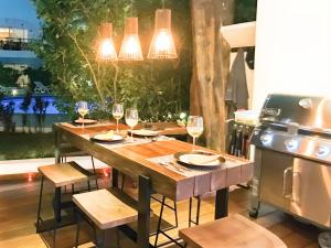 ein Holztisch mit Weingläsern und einem Herd in der Unterkunft Luxury Duplex 2BR Pool & Garden View Quiet 30m from 5th Ave with Gym & Parking in Playa del Carmen