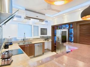 eine große Küche mit Spüle und Kühlschrank in der Unterkunft Luxury Duplex 2BR Pool & Garden View Quiet 30m from 5th Ave with Gym & Parking in Playa del Carmen