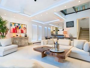 ein Wohnzimmer mit einem weißen Sofa und einem Tisch in der Unterkunft Luxury Duplex 2BR Pool & Garden View Quiet 30m from 5th Ave with Gym & Parking in Playa del Carmen + 48 Fotos