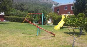 a yard with a playground with a slide at Aristidis Garden in Parga