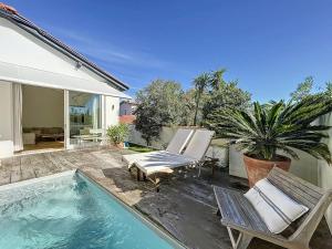 a patio with two chairs and a swimming pool at Maison 4 Chambres Côte des Basques Avec Piscine in Biarritz