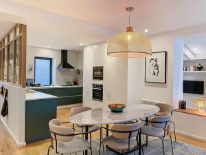a kitchen and dining room with a table and chairs at Maison 4 Chambres Côte des Basques Avec Piscine in Biarritz