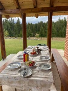 扎布利亚克House in forest的一张木桌,上面放着食物盘