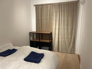a bedroom with a bed and a table and a window at City Center ocean view Vervet apartment in Tromsø