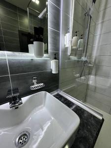 a bathroom with a white sink and a shower at Home Boutique Hotel in Tashkent