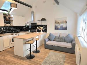 a kitchen and living room with a couch and a table at The Mews, Whetstone in Leicester