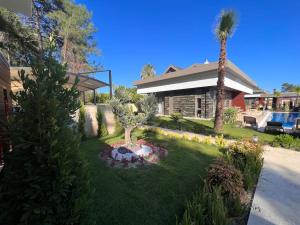 a yard with a palm tree and a house at Kemer Green Park Villa in Kemer