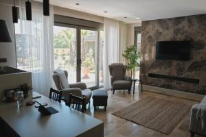 a living room with a table and chairs and a television at Kemer Green Park Villa in Kemer