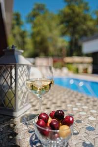 a glass of wine and a bowl of fruit on a table at Kemer Green Park Villa in Kemer
