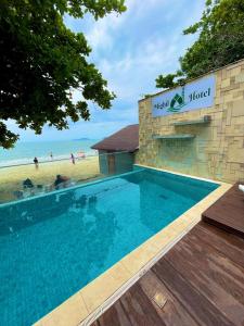 a swimming pool in front of a building with a beach at Mighil Hotel in Florianópolis +16 photos