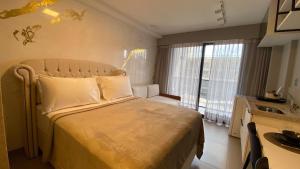 a bedroom with a large bed with a large window at Beach Haus by Hosppedar in João Pessoa +45 photos