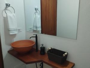 Un baño con lavabo de madera y espejo. en Casa María Trinidad, en Villa de Leyva
