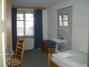 bagno con lavandino, letto e finestra di Hotel Danis a Lenzerheide