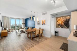Una sala de estar con una mesa y un comedor. en Top Luxury Apartment with Pool & Gym, en Hallandale Beach