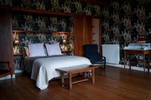 a bedroom with a bed and a desk and a chair at maison bourgeoise in Rouffignac
