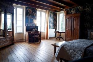 a bedroom with a bed and a desk and windows at maison bourgeoise in Rouffignac +23 photos