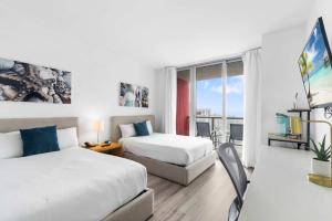 a hotel room with two beds and a balcony at Modern New Studio Balcony & Pool in Hallandale Beach