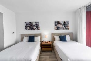 two beds sitting next to each other in a room at Modern New Studio Balcony & Pool in Hallandale Beach